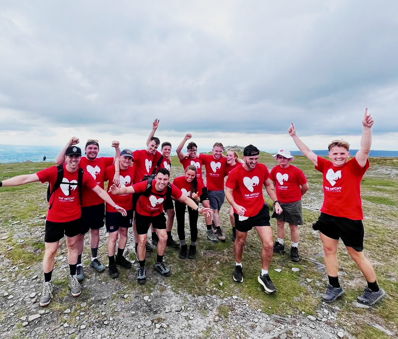 A group of supporters celebrating on open moorland during the Yorkshire Three Peaks fundraiser.
